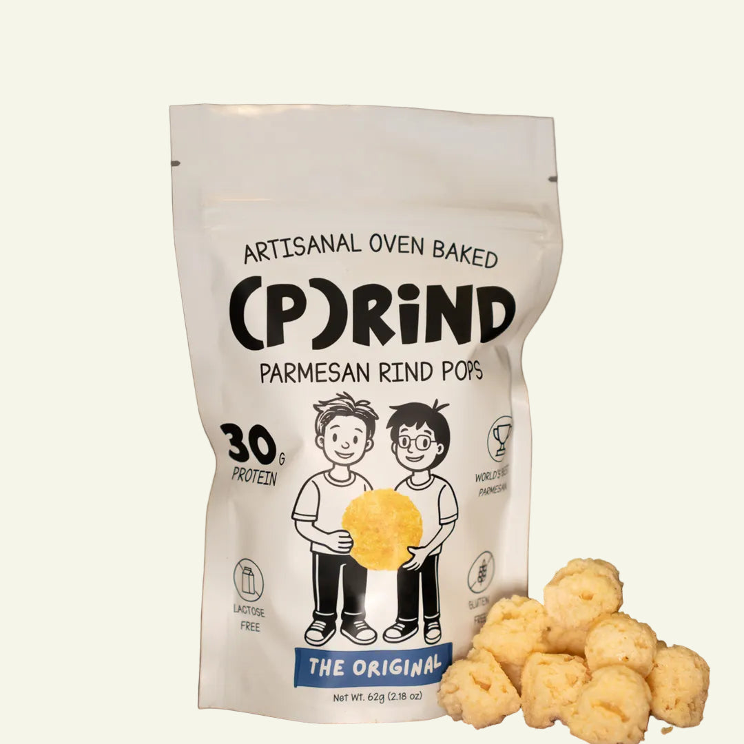Bag of (P)RIND Parmesan Rind Pops with popcorn on a wooden surface
