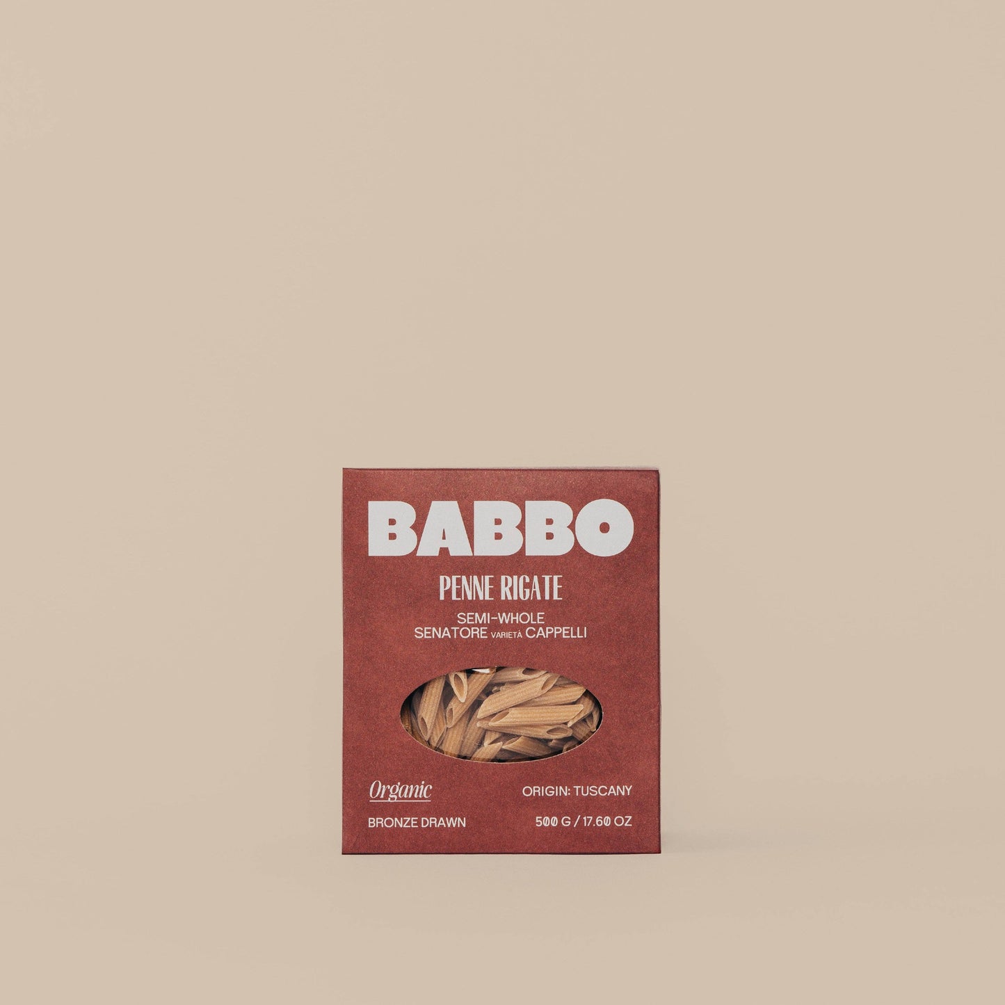 A package of Babbo brand Semi-Whole Grain Penne pasta made from Senatore Cappelli wheat, with a visible window showing the dried pasta inside.