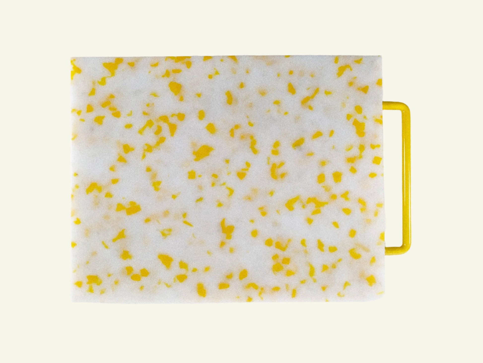 White cutting board with yellow speckles and a yellow handle on a white background