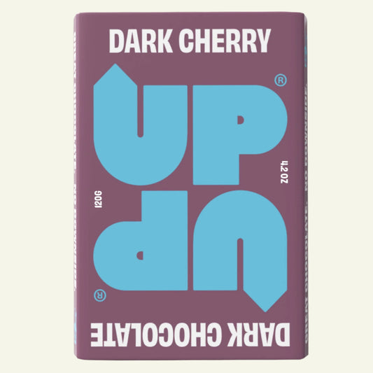 A chocolate bar packaging with 'UP UP Dark Cherry' text in capital letters, with the color blue on a purple background.