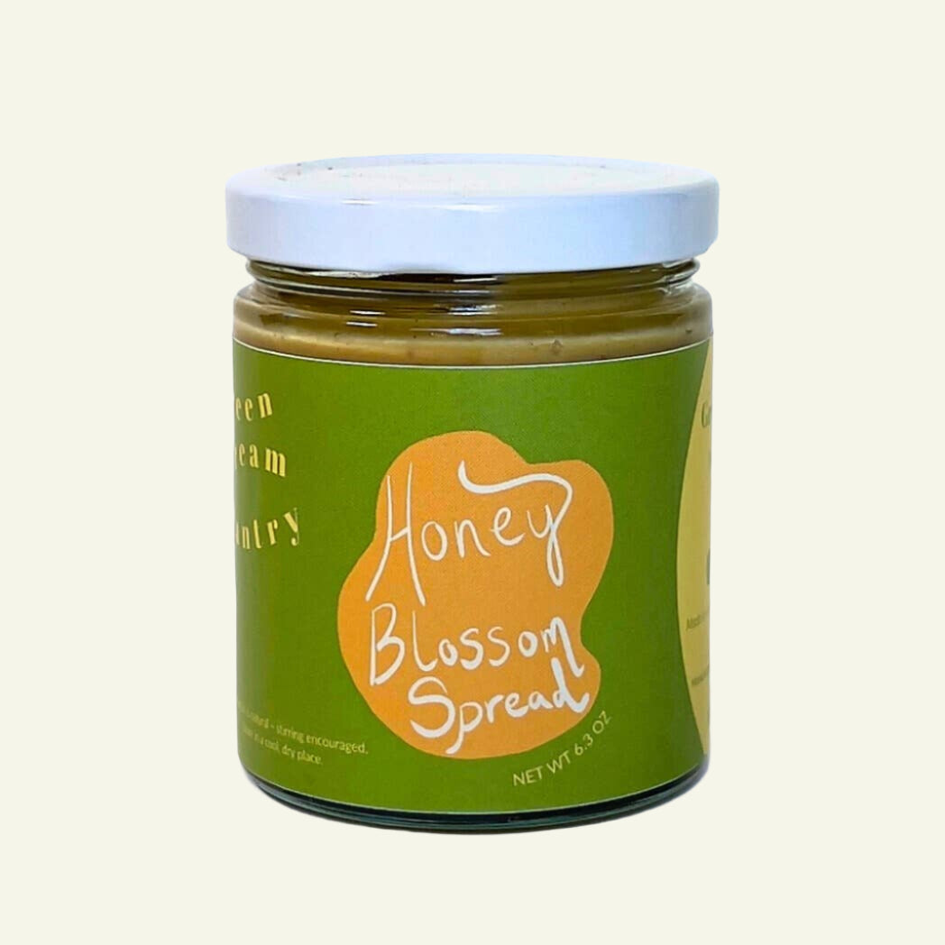 Jar of Honey Blossom Spread with a green label on a white background
