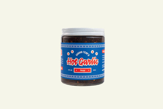 A jar of Hot Garlic Chili Crisp with a blue and red label on a white background.
