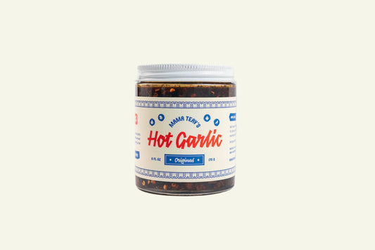 A jar of Hot Garlic Chili Crisp with a white and red label, indicating it is an original recipe product.