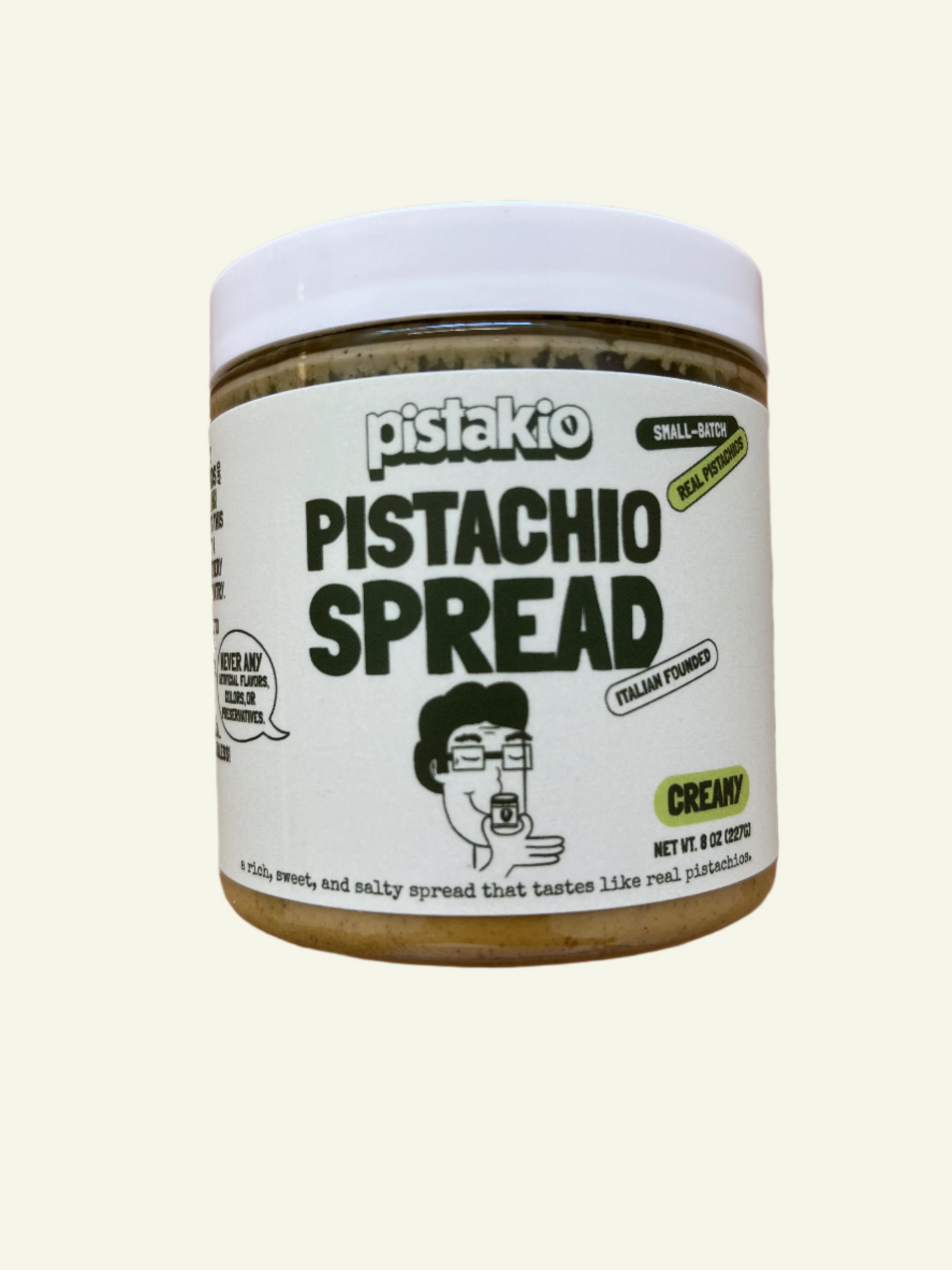 Jar of pistachio spread with a white label on a wooden surface