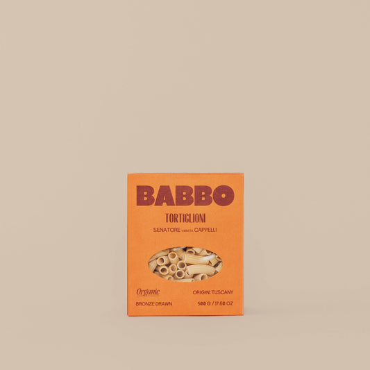 Package of Babbo Tortiglioni pasta with an orange and white design, featuring an image of the pasta and the brand name.