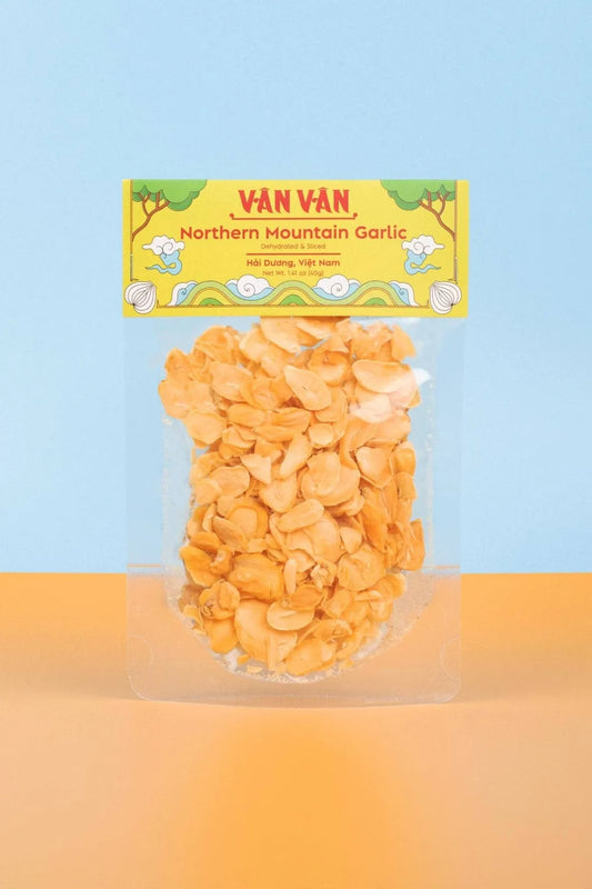 Packaged garlic cloves with Van Van branding on a gradient background